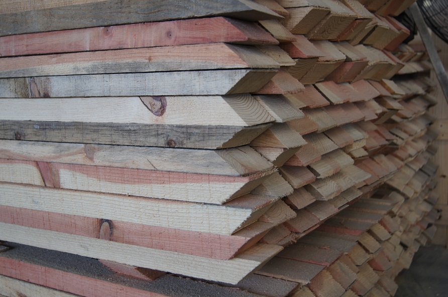 Estos son los tipos de madera para construcción. Imagen de una pila con los diferentes tipo de madera para construcción con detalles de color y la punta en diagonal.