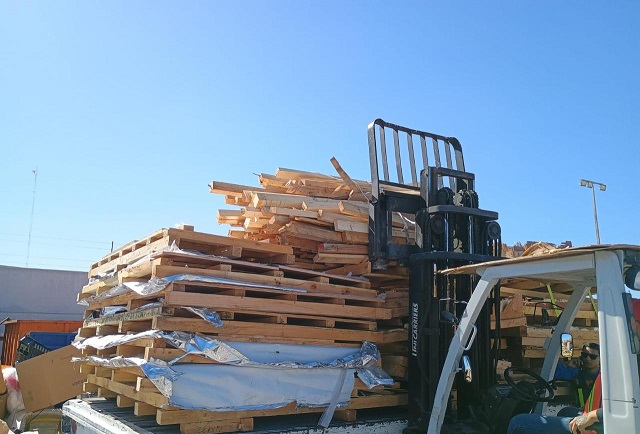 Montacargas llevando tarimas de madera recicladas a revisión Toma fotográfica de un montacargas transportando tarimas de madera recicladas para su inspección a detalle