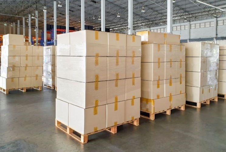 Tarimas y cajas de madera utilizados como soluciones de embalaje. Imagen de un gran lote de tarimas que cargan cajas de cervezas utilizados como soluciones de embalaje.