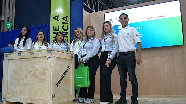 Imagen de colaboradores de la empresa vestidos de blanco posando para una fotografía después de dar una explicación sobre cajas.