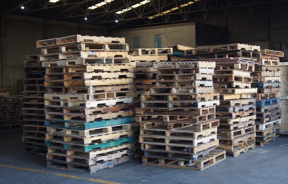 Pallets reciclados utilizados en un centro logístico Imagen de un centro de distribución de pallets reciclados utilizados listos para su uso.