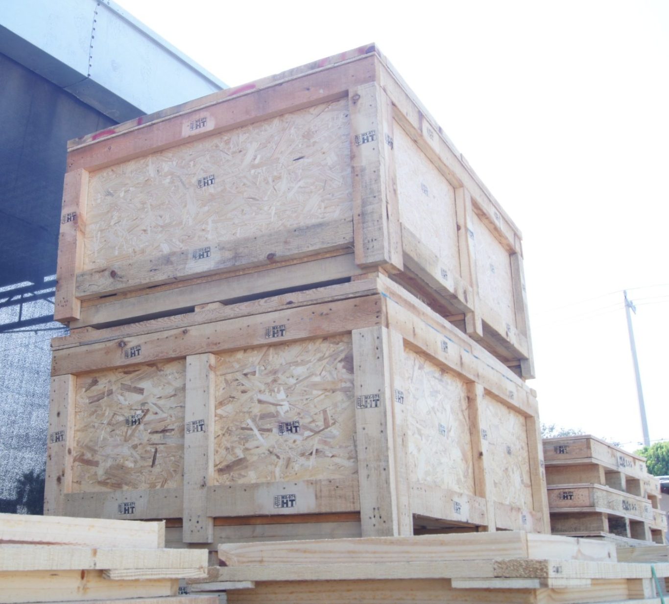 Contenedores apilados al exterior, evidenciando la durabilidad de la fabricación de cajas de madera que elabora Prommont 
