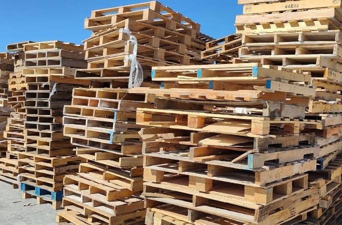 Pallets reciclables clasificados en un patio industrial listos para regenerar Imagen de pallets viejos y de desecho clasificados en un patio industrial listos para regenerar.