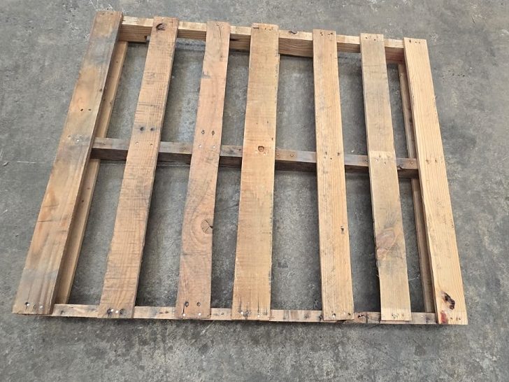 Venta de tarimas de madera con volado Imagen de tarima de madera con volado que muestra las tablas superiores extendiéndose más allá de los soportes.