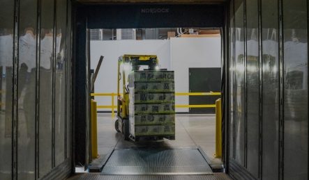 Tarimas totalmente personalizadas: Montacargas llevando tarimas personalizadas para la caja de camión Tarimas totalmente personalizadas: Fotografía de un montacargas llevando consigo una gran cantidad de tarimas personalizadas hacia una caja